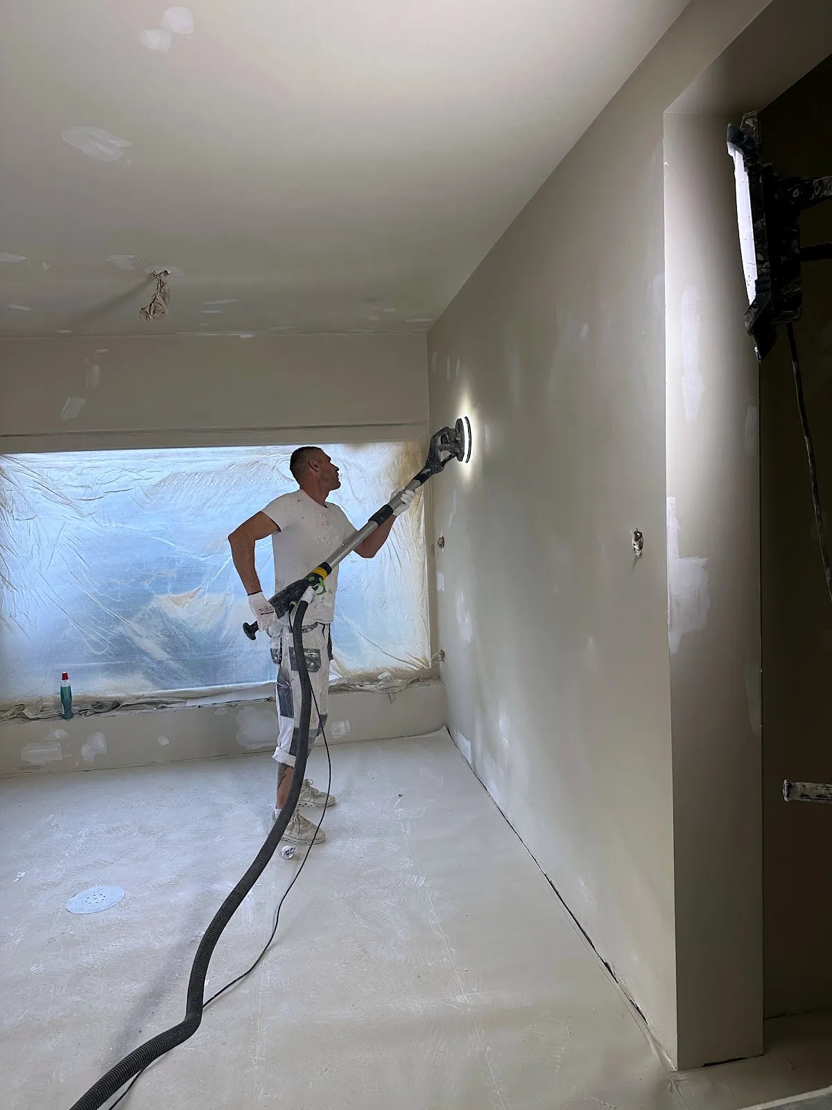 Stukadoor van Stucfabriek aan het werk aan een wand