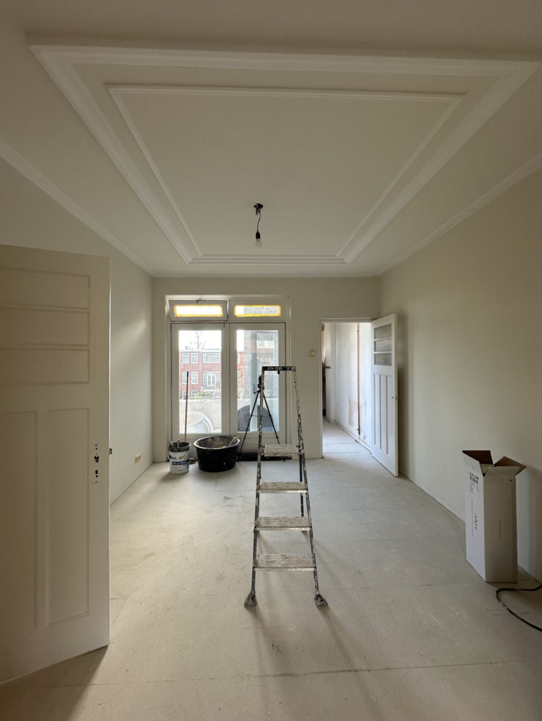Lange kamer met nieuw gestucte wanden en plafond met lijstwerk