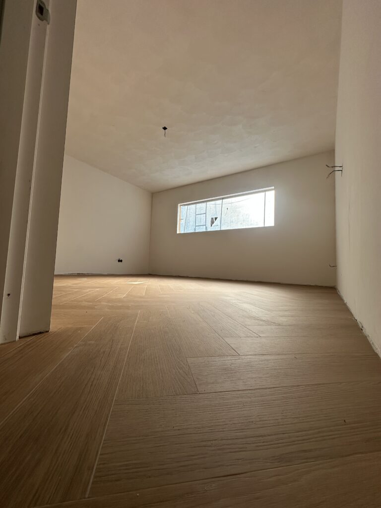 Kamer met strak gestucte wanden en visgraatvloer