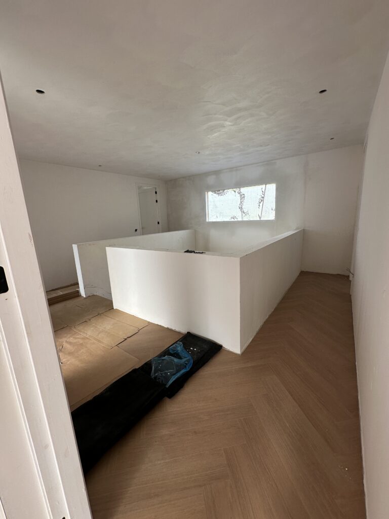 Strak gestucte wanden en plafond rond een trapgat in een nieuwbouwwoning