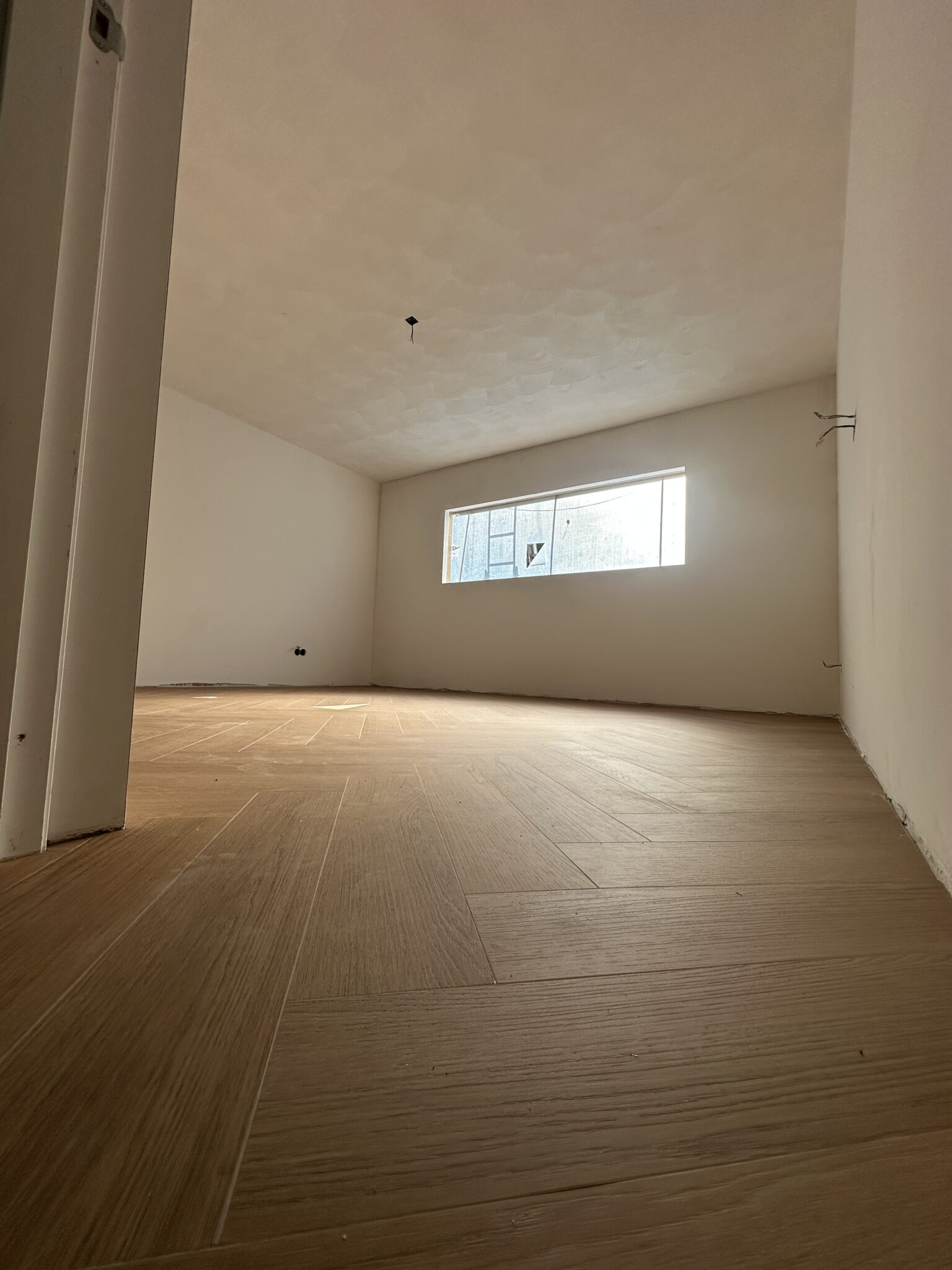 Strak gestucte wanden en plafond in een lichte kamer, opgeleverd door Stucfabriek Groningen